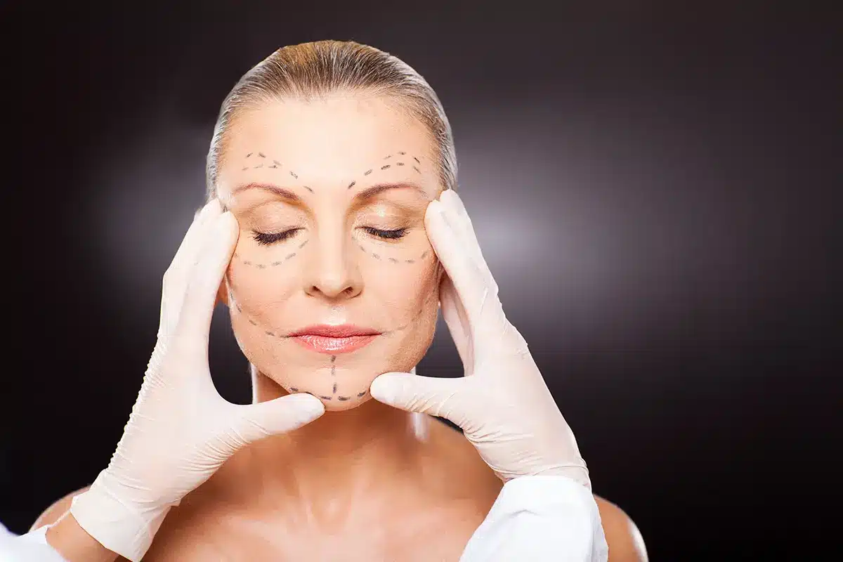 plastic surgeon checking middle aged woman face