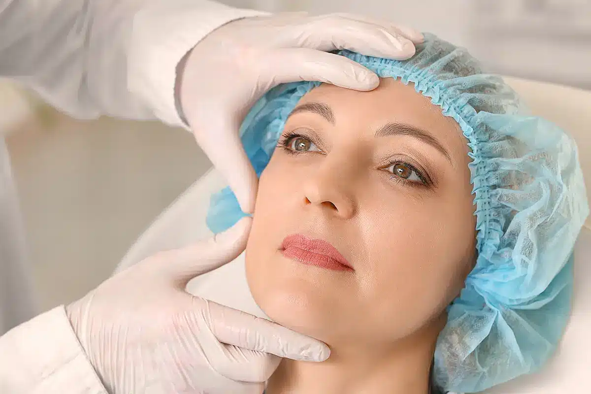 plastic surgeon examining womans face in clinic plastic surgeon examining womans face in clinic