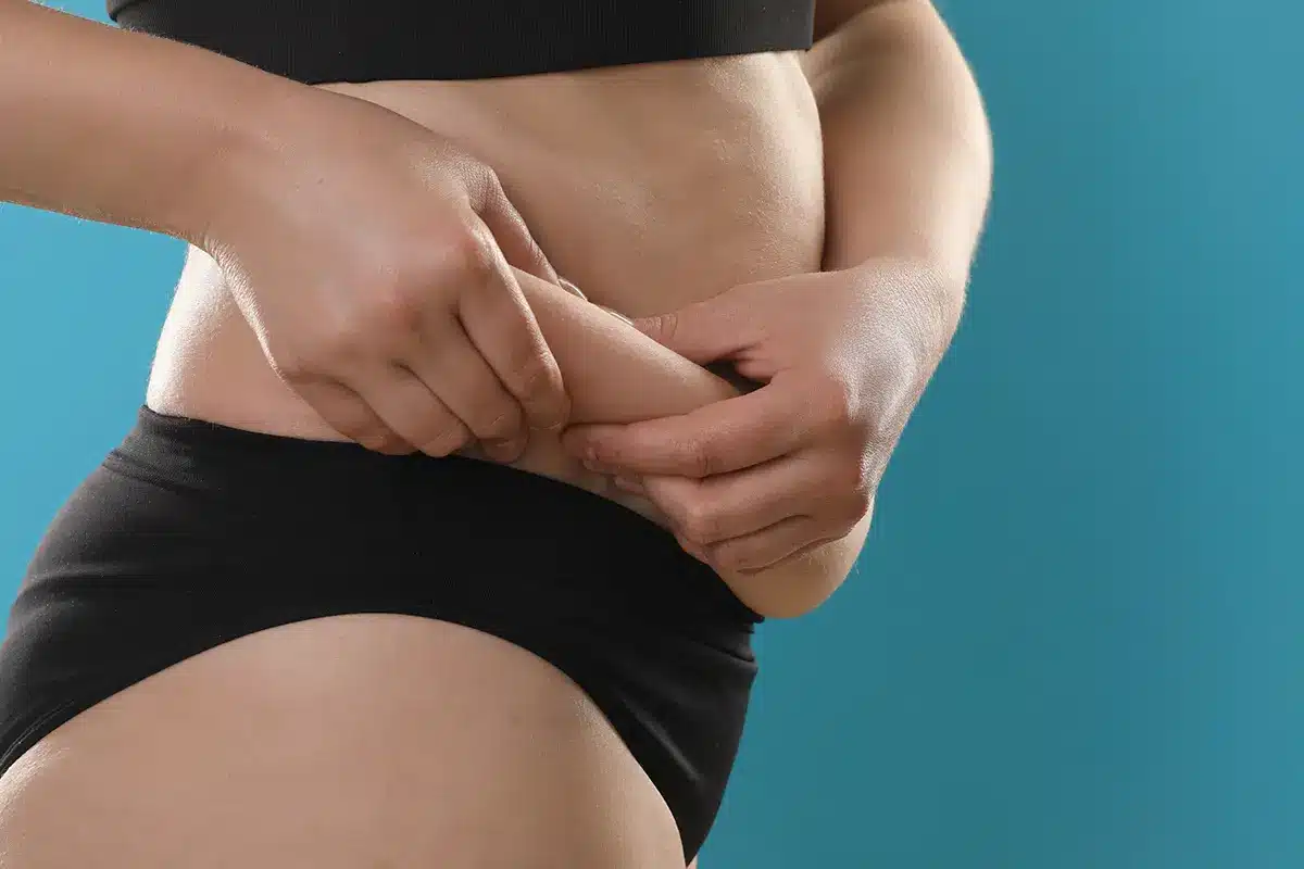 woman touching love handles woman touching love handles